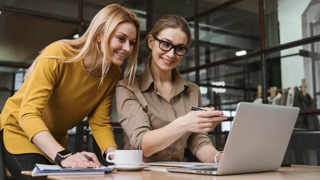 young smiley businesswomen working with laptop desk
